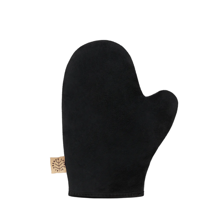 Black exfoliating mitt for body scrubbing, featuring soft textured fabric and brand tag, ideal for spa-like skin care routines.