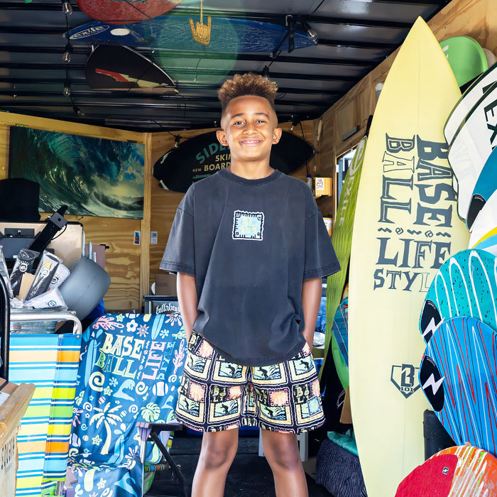 Youth model wearing black youth graphic tee with "Wave Goodbye" design