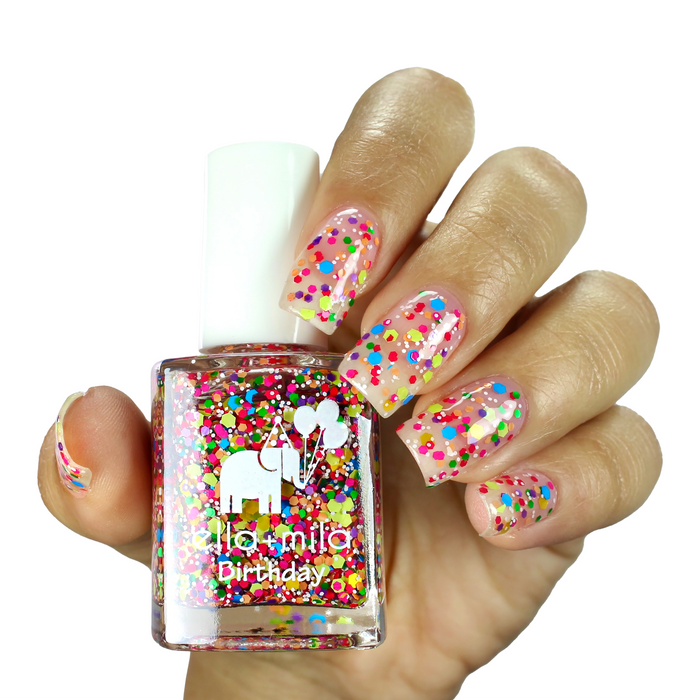 Ninth Street colorful confetti nail polish on a medium skin tone, hand holding the bottle