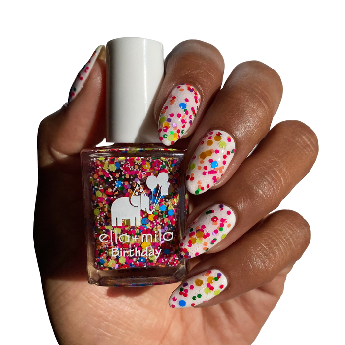 Ninth Street confetti glitter nail polish on a deep skin tone, holding the bottle