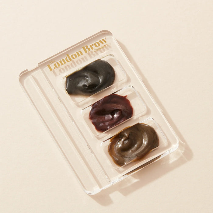 Set of three eyebrow products in a clear plastic case with 'London Brow' branding on a beige background.