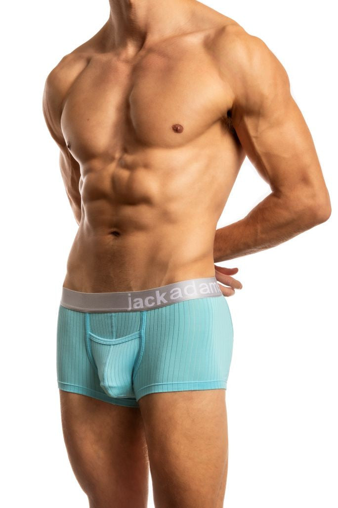 Shirtless man standing in front of a white background wearing a pair of Jack Adams Air Army Wide Ribbed Trunks in aquarius (profile view)