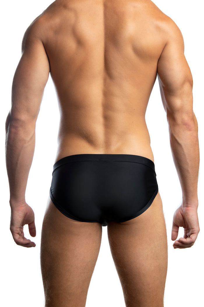Man standing wearing a pair of Jack Adams black Apollo Swim Brief (back view) on a white background.