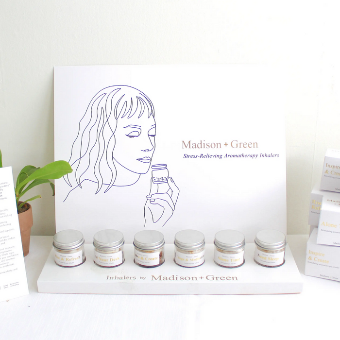 Aromatherapy inhaler sampler display with multiple small glass jars and boxes