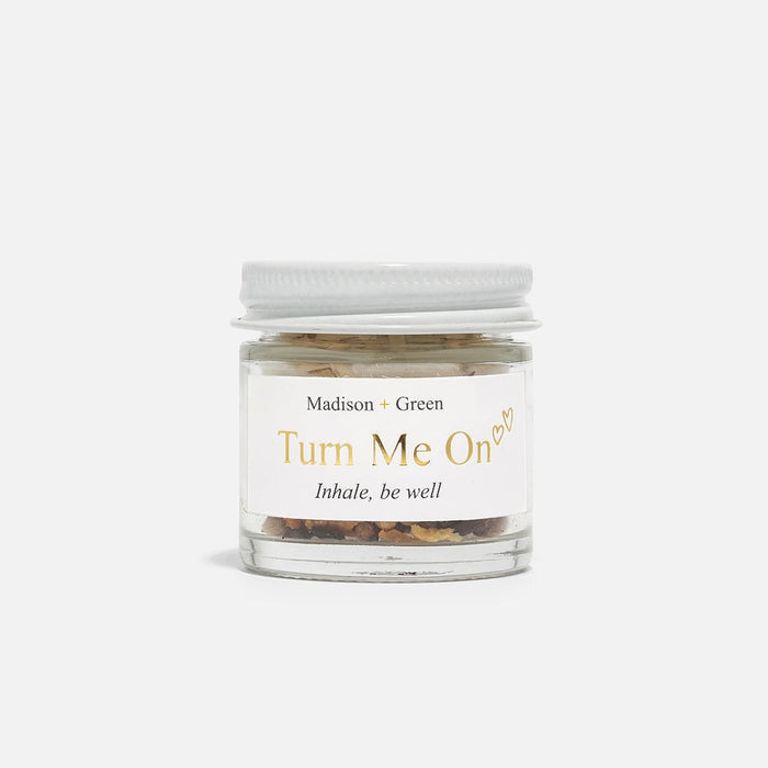 Aromatherapy inhaler jar labeled Turn Me On with white screw lid