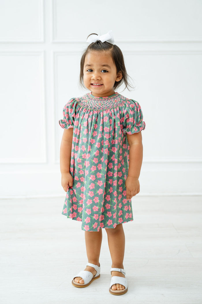 A little girl wearing the smocked azaleas Helen dress radiates elegance at any spring celebration.