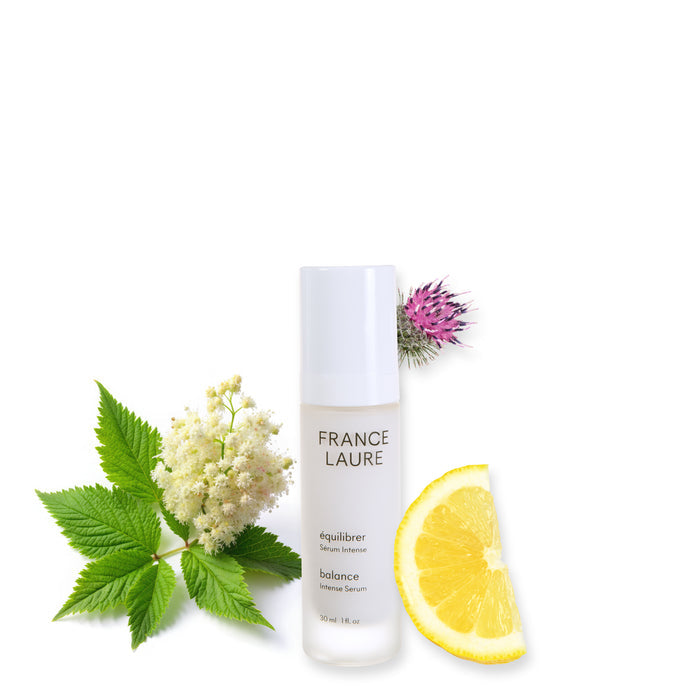 France Laure Balance Intense Serum bottle with fresh lemon slice, green leaves, and flowers on white background