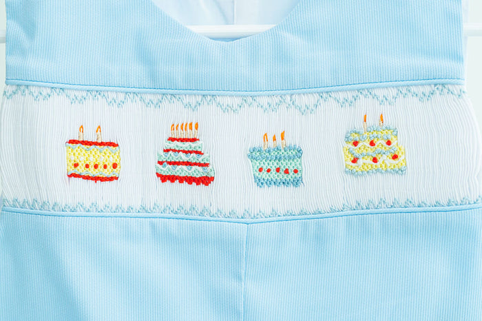 Up close image of birthday cake smocking across chest.