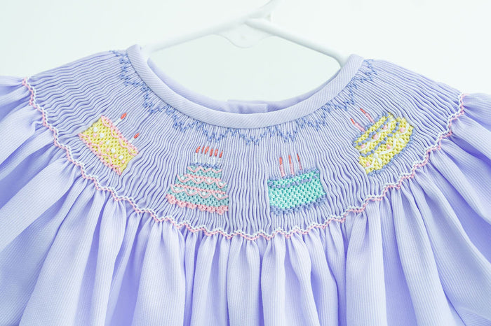 Up close image of birthday cake smocking across collar.