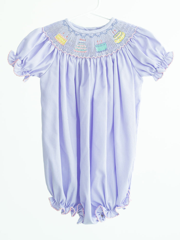Birthday Girl Birdie Bubble is a cute smocked bubble featuring birthday cake designs on a super soft and comfortable polyester/cotton blend. Perfect for celebrating her special day, this charming ensemble adds a touch of sweetness to her birthday festivities, it comes in sizes for toddlers 12M to 3T.