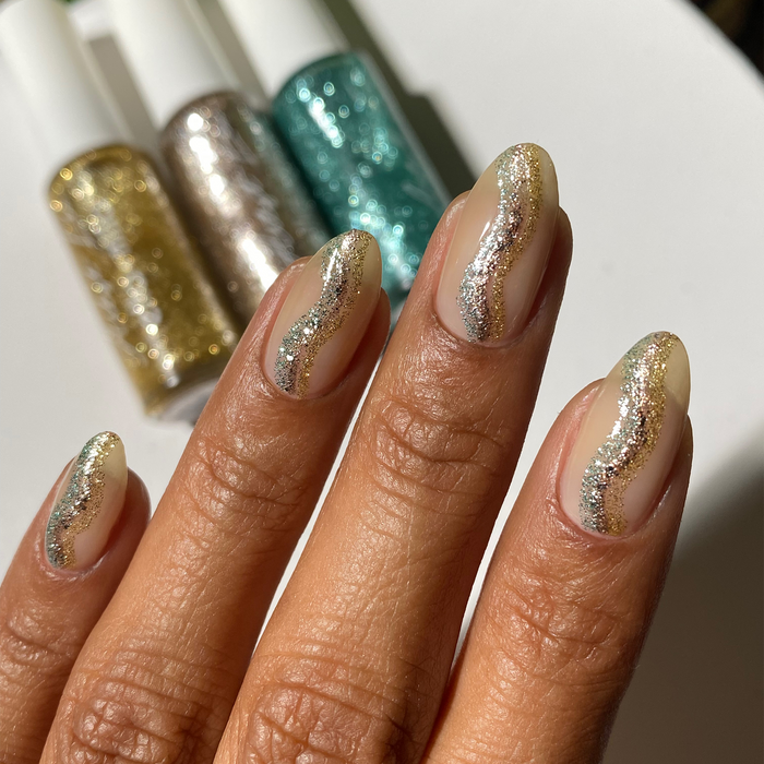 Bluminescence and glitter liners nail art on a nude manicure with the bottles