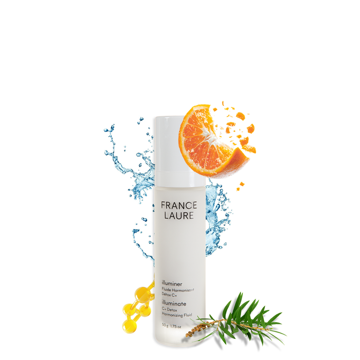 France Laure Illuminate C+ Detox Harmonizing Fluid bottle with orange slice, water splash, and green leaves, showcasing brightening skincare formula.