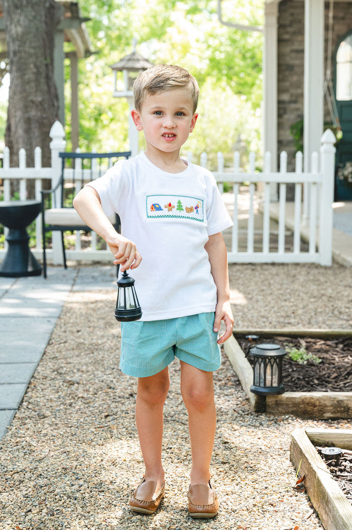 Boy standing outdoors wearing Camping Smocked Beau T-Shirt and Shorts Set with green gingham shorts