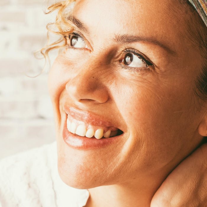 Close-up of smiling woman with natural skin texture, showcasing radiant complexion and healthy glow for all skin types