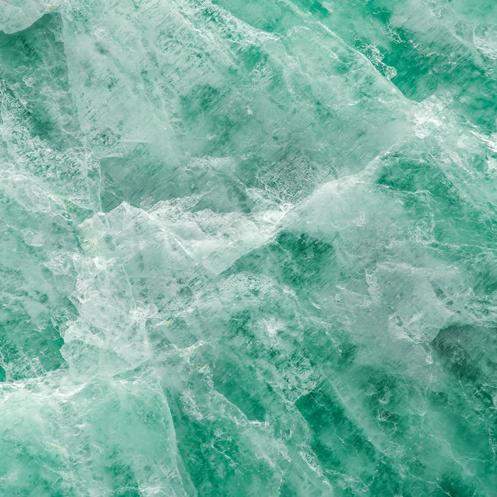 Close-up of crystalline turquoise ice texture, evoking purity and hydration for skincare products