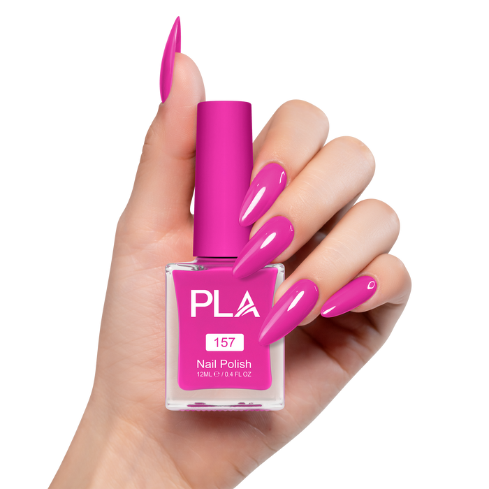 Hand holding a pink nail polish bottle with matching nails on a white background