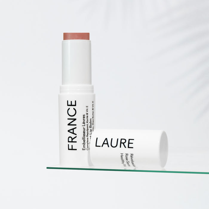 France Laure Healthy Pink lip balm with shea butter & vitamin E, shown uncapped on glass shelf against white background