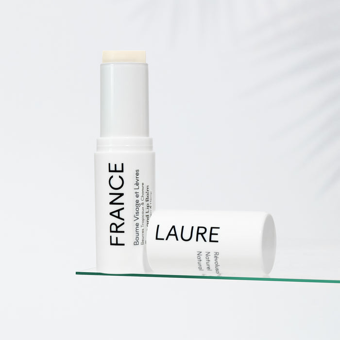 France Laure natural face and lip balm with tropical butters and hemp, shown uncapped on glass against soft white background