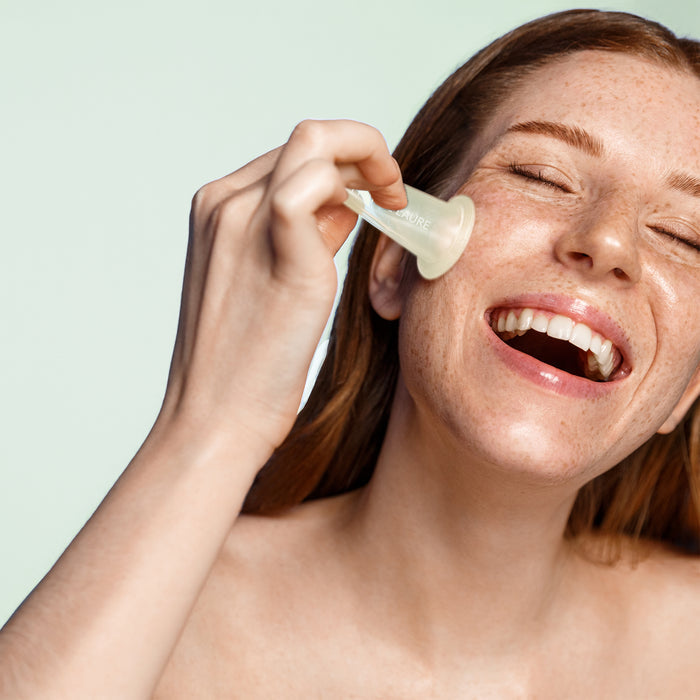 Woman applying facial serum with dropper for glowing skin care routine, targeting hydration and radiance for all skin types