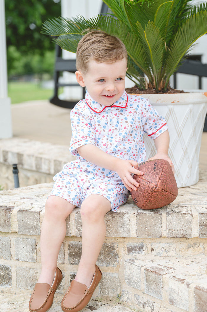 Young boy modeling a soft Pima cotton football-print romper with polo collar, perfect for tailgates and game days
