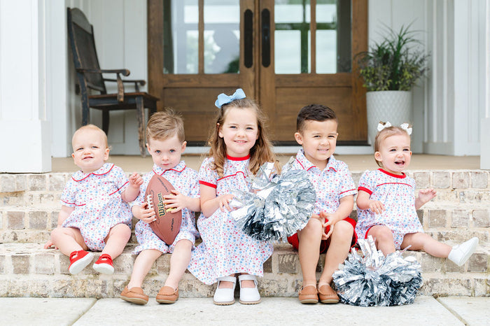 Toddler in a soft Pima cotton football-print polo and red shorts, perfect for game days and tailgates