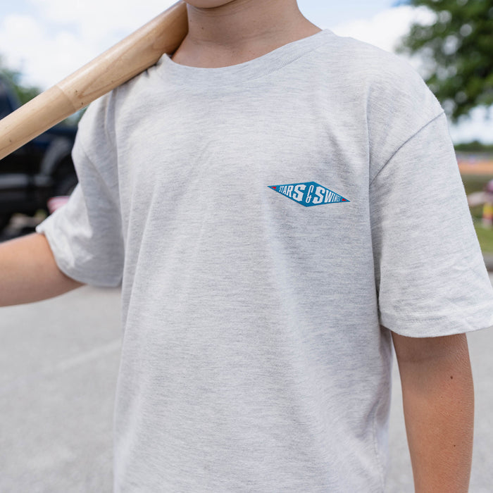 Close-up of youth male model wearing heather gray Freedom Swings tee showing Stars and Swings logo on chest while holding baseball bat