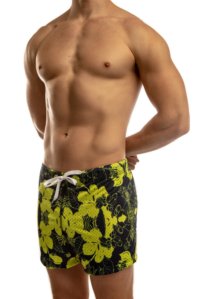 Man standing wearing a pair of Jack Adams hibiscus royal-yellow Freestyle Mesh Shorts (profile view) on a white
