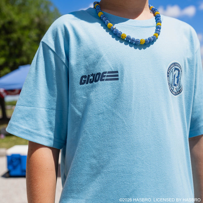 Close-up of youth model in light blue GI Joe tee showing GI Joe logo and BL101 badge on chest