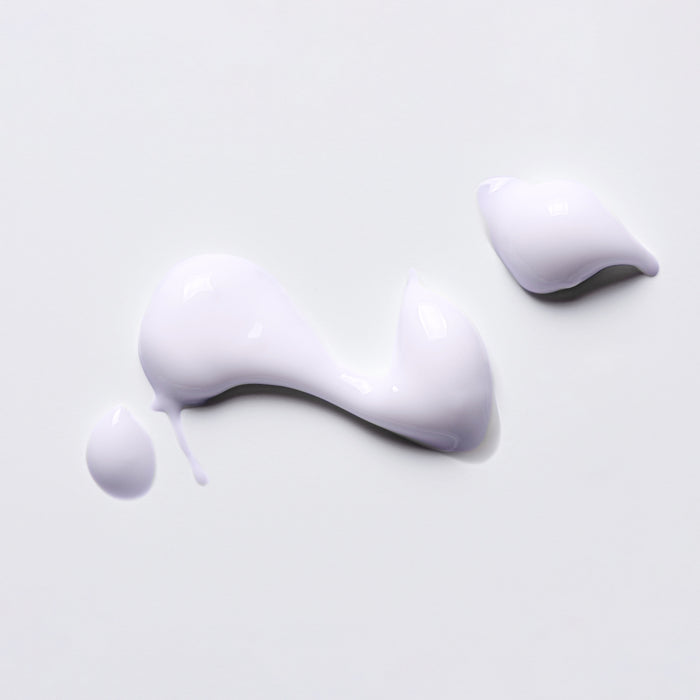 Smooth lavender cream swatch with glossy texture on white background, showcasing luxurious skincare product consistency