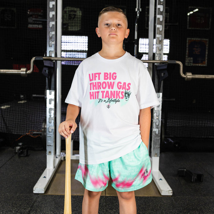 Youth model wearing white graphic tee with "Hit Tanks" design