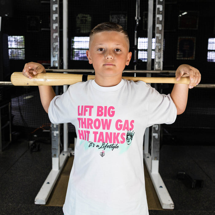 Youth model wearing white graphic tee with "Hit Tanks" design
