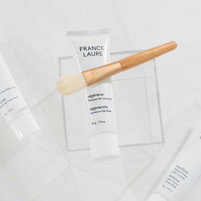 France Laure Regenerate Jouvence Gel Mask tube with wooden-handled applicator brush, shown on clear stand against white background