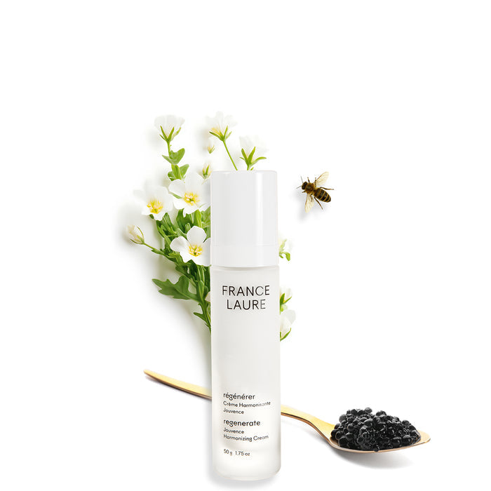 France Laure Regenerate Jouvenance Harmonizing Cream bottle with white flowers, bee, and black caviar on gold spoon, 50g