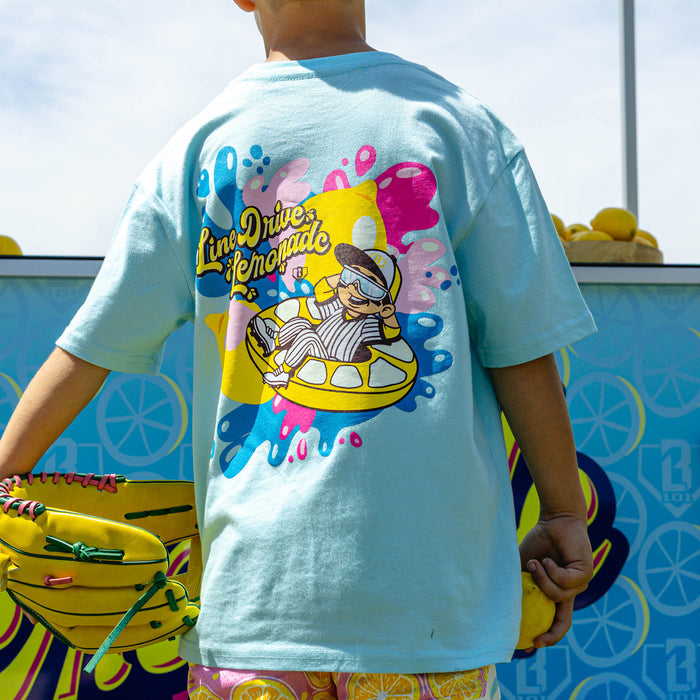 Youth model wearing blue youth graphic tee with "Lemon Burst" design