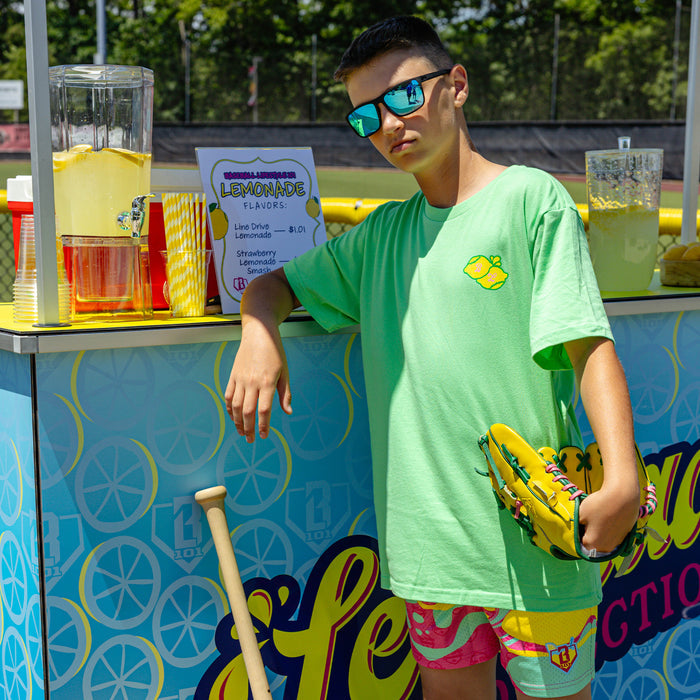 Youth model wearing green youth graphic tee with "Lemon Dingers" design