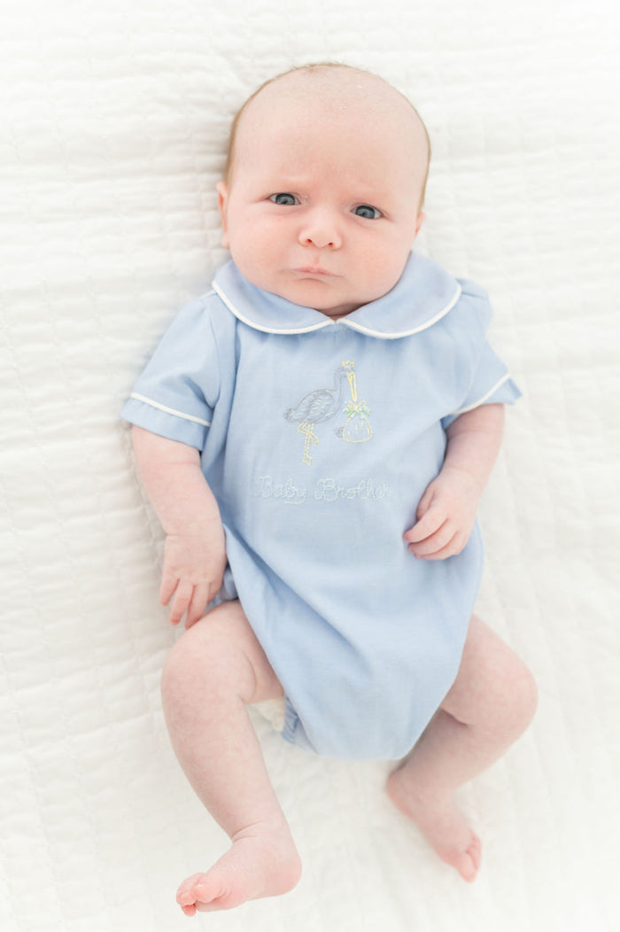 A baby boy looks adorable in this classic bubble, featuring delicate stork embroidery and "Baby Brother" lettering.