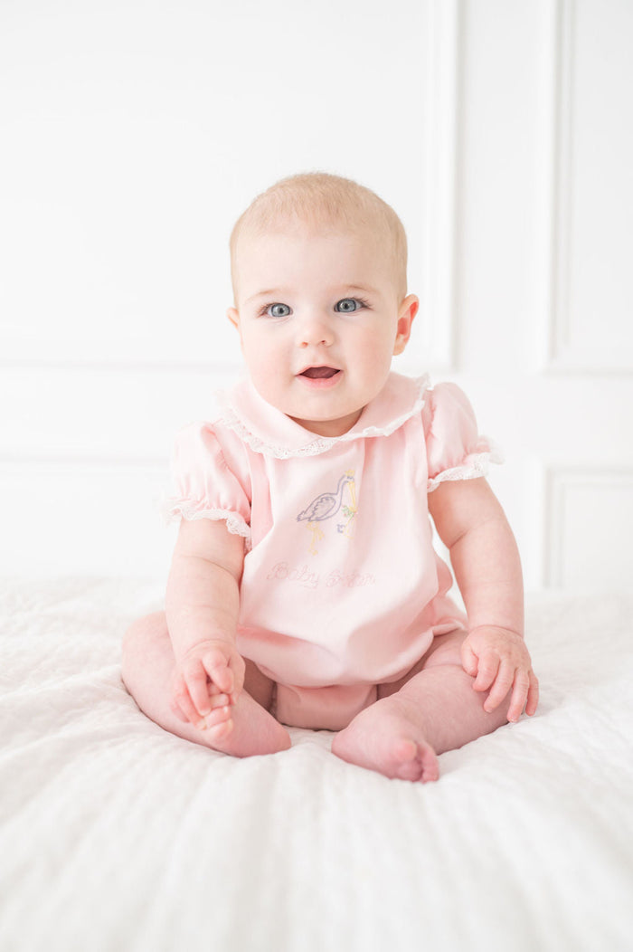 A baby girl will look absolutely precious in this classic bubble with delicate stork embroidery and "Baby Sister" lettering.