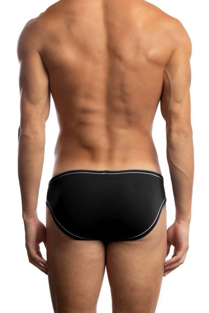 Shirtless man standing in front of a white background wearing a pair of Jack Adams LUX Profile Brief (w/ piping) in black (w/ white piping) (back view)