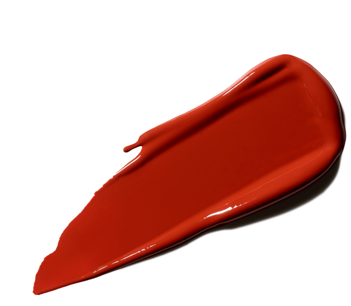 M.A.C LustreGlass sheer-shine lipstick in Chili Popper, showing a smooth lipstick swatch with a glossy finish on a neutral background.