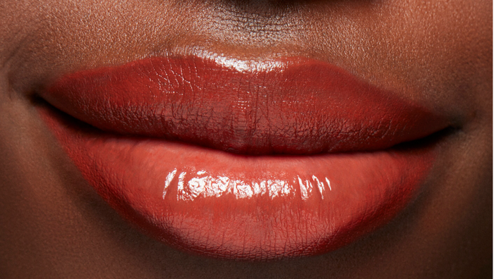 M.A.C Lustreglass Sheer-Shine Lipstick in Chili Popper showing vibrant coral-orange lip gloss with glossy finish.