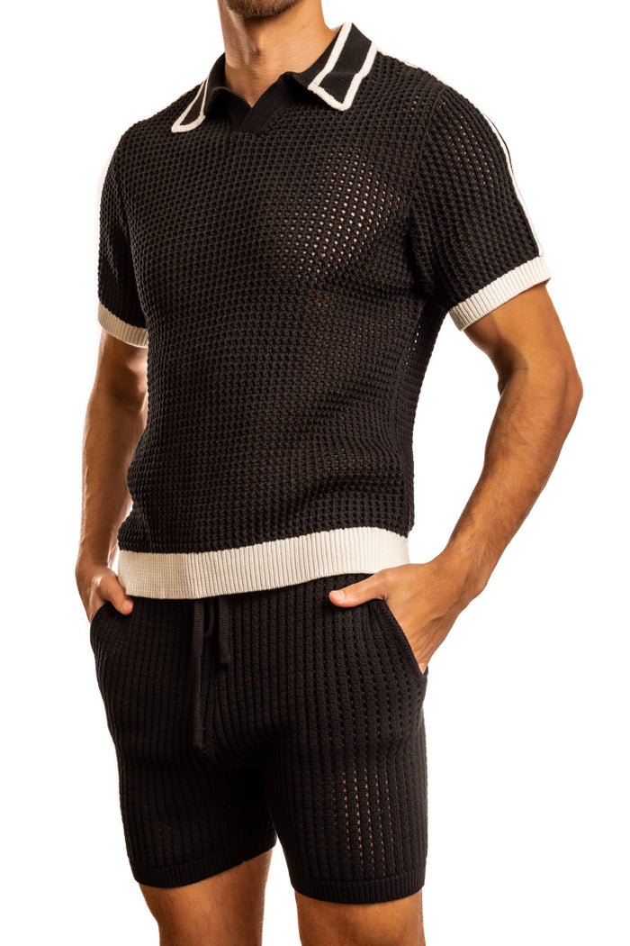 Man standing wearing a pair of Jack Adams black Matteo Crochet Knit Pull Over Shirt (profile view) on a white background.