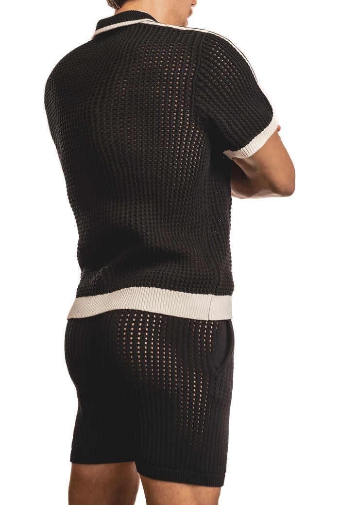 Man standing wearing a pair of Jack Adams black Matteo Crochet Knit Pull Over Shirt (back view) on a white background.