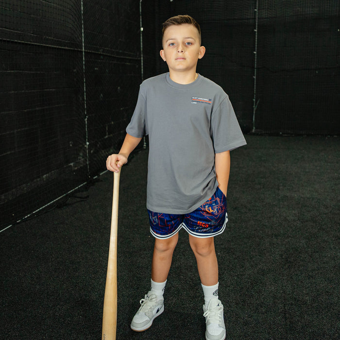 Child holding a baseball bat in an indoor sports facility