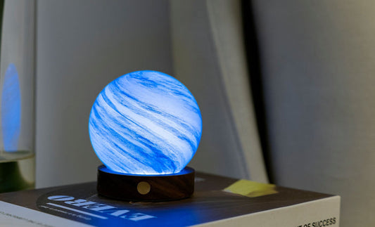 Swirling blue glass globe light on dark base