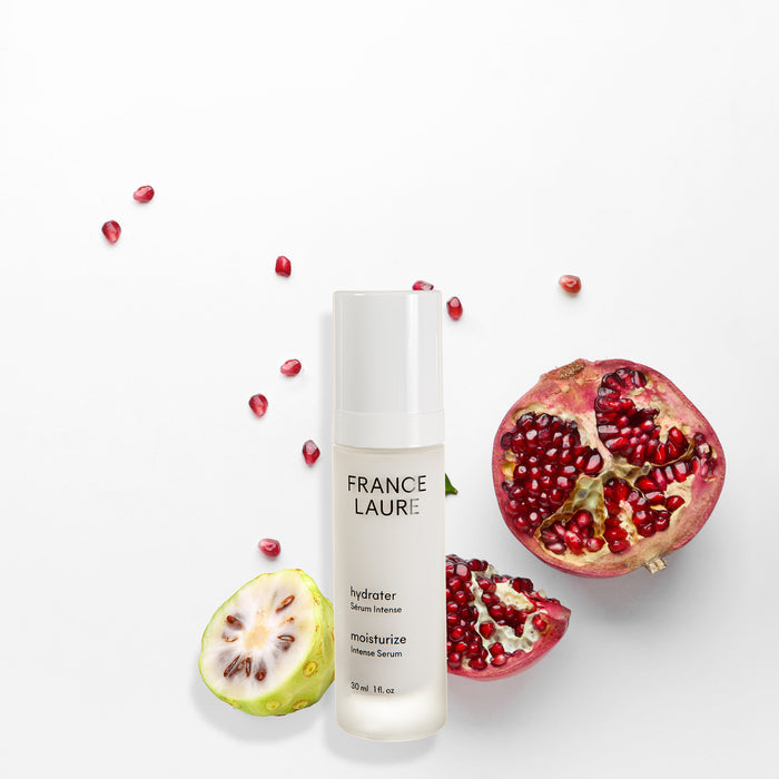 France Laure Hydrater Intense Serum bottle with pomegranate and guava slices, showcasing natural ingredients for deep skin hydration and moisture.