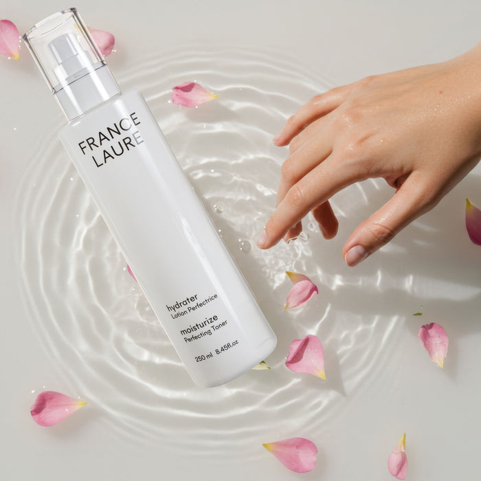France Laure Hydrater Moisturize Perfecting Toner bottle with hand in water and rose petals, 250ml skincare product
