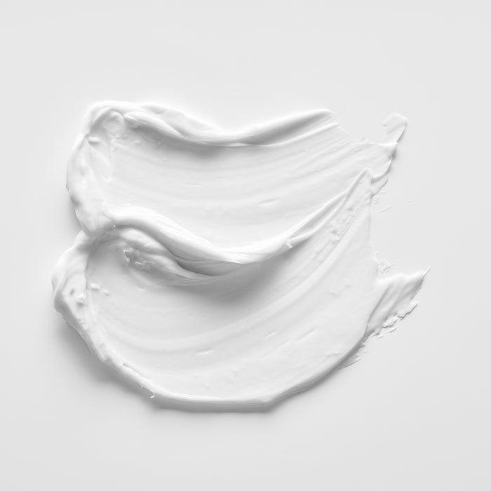 Smooth white skincare cream swatch on clean background, showcasing rich texture for all skin types