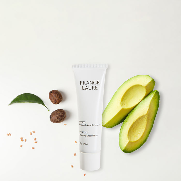 France Laure Nourish Repairing Cream Mask tube with fresh avocado slices, nuts, and leaf on white background for natural skincare