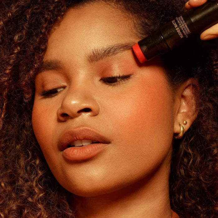 NUDESTIX Nudies Blush Stick in multiple shades, showing a sleek beige tube with vibrant blush colors visible on the product.