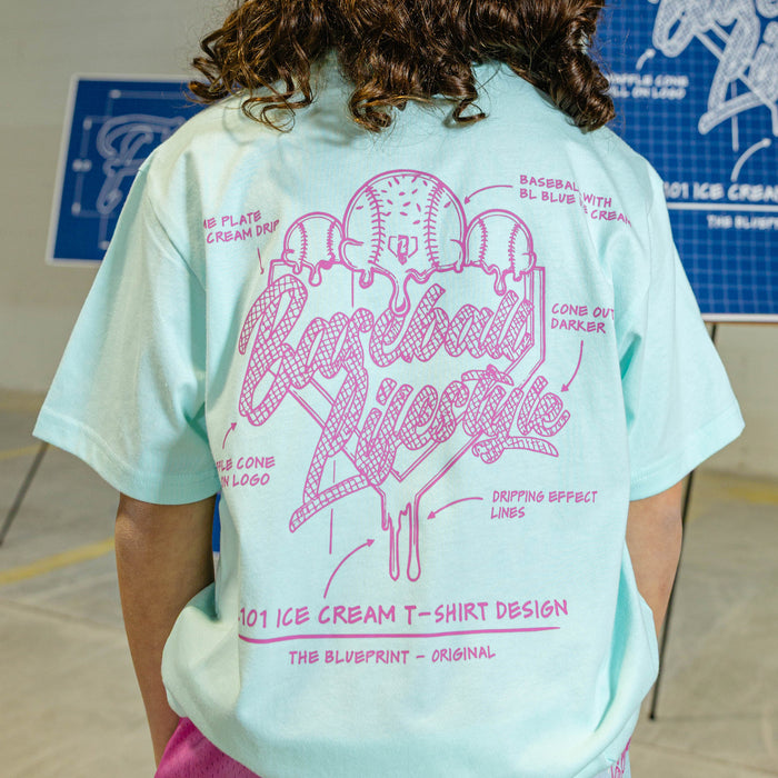 Person wearing a light blue t-shirt with pink ice cream graphic and "Baseball Lifestyle 101" logo